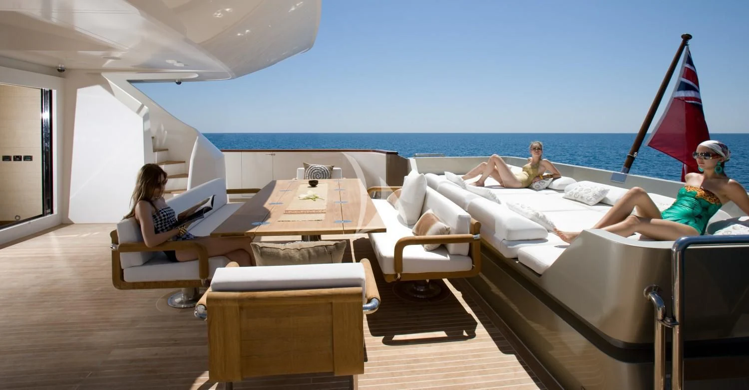 a group of people sitting on a couch in a room with a flag aboard QHT Yacht for Sale