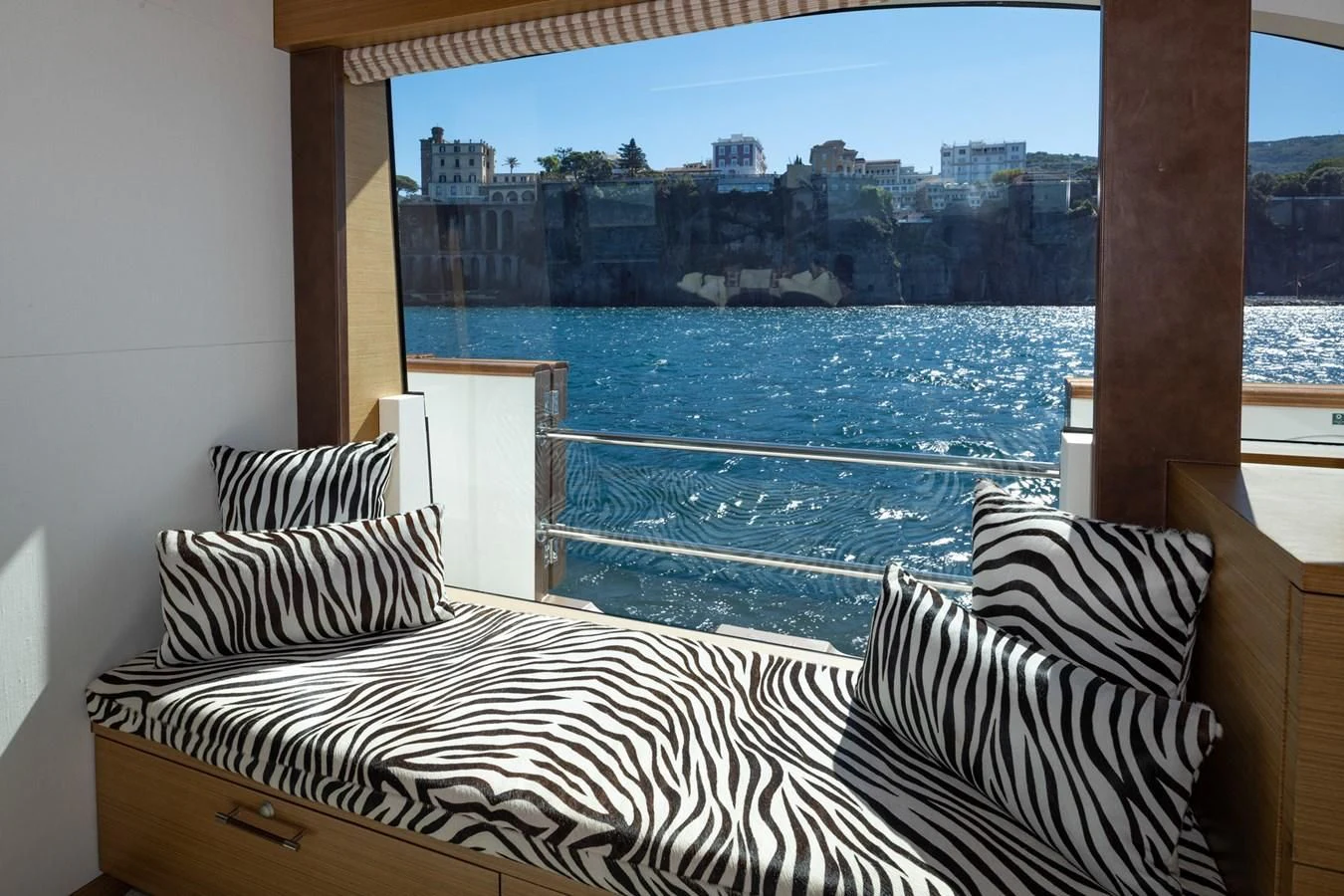 a bed and a window overlooking a city aboard QHT Yacht for Sale