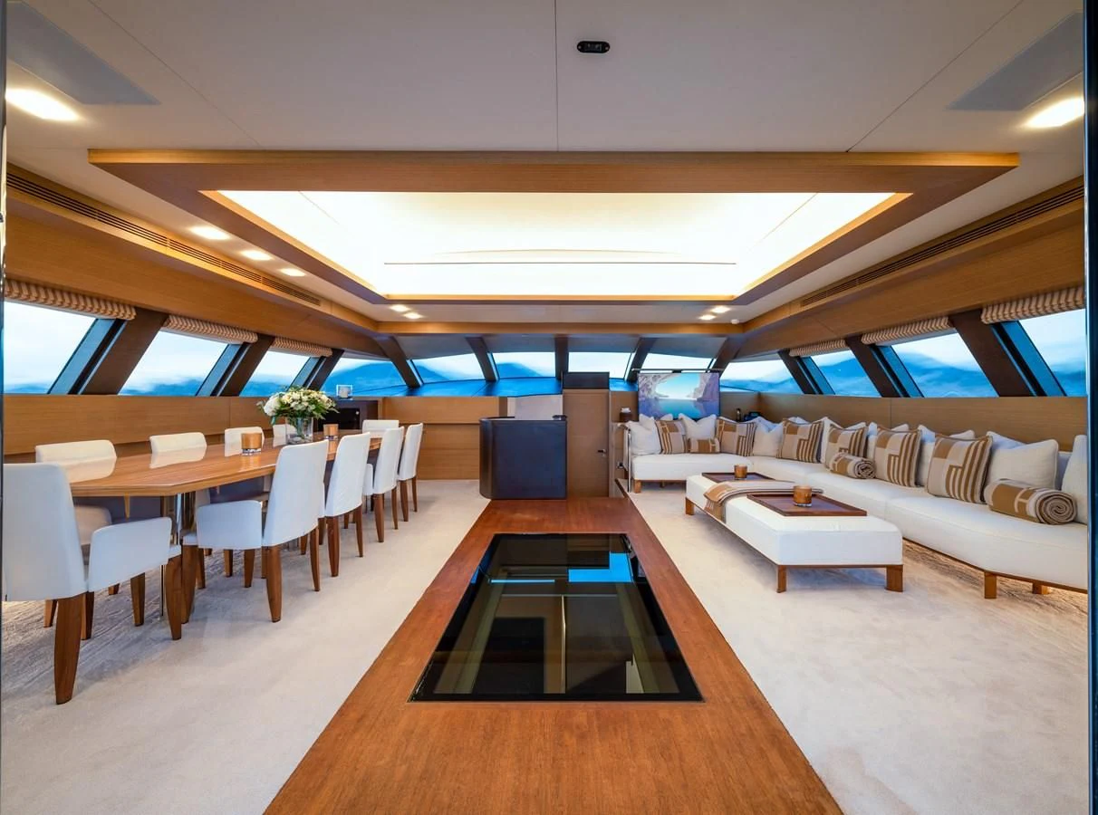 a room with tables and chairs aboard QHT Yacht for Sale