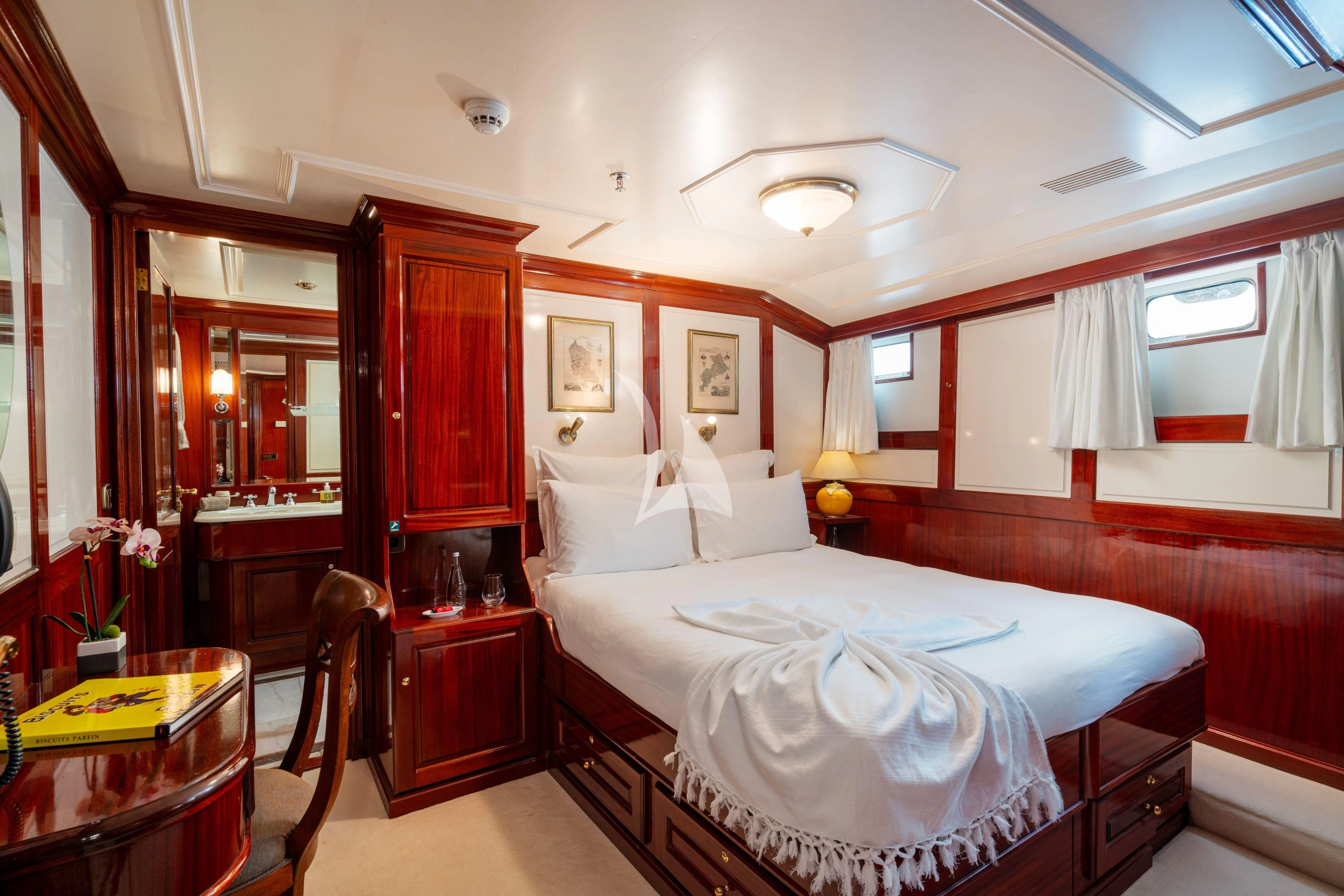 a bedroom with a bed and a desk aboard SEA LION Yacht for Sale