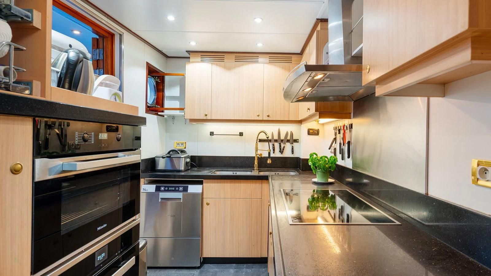 a kitchen with black appliances aboard SEA LION Yacht for Sale