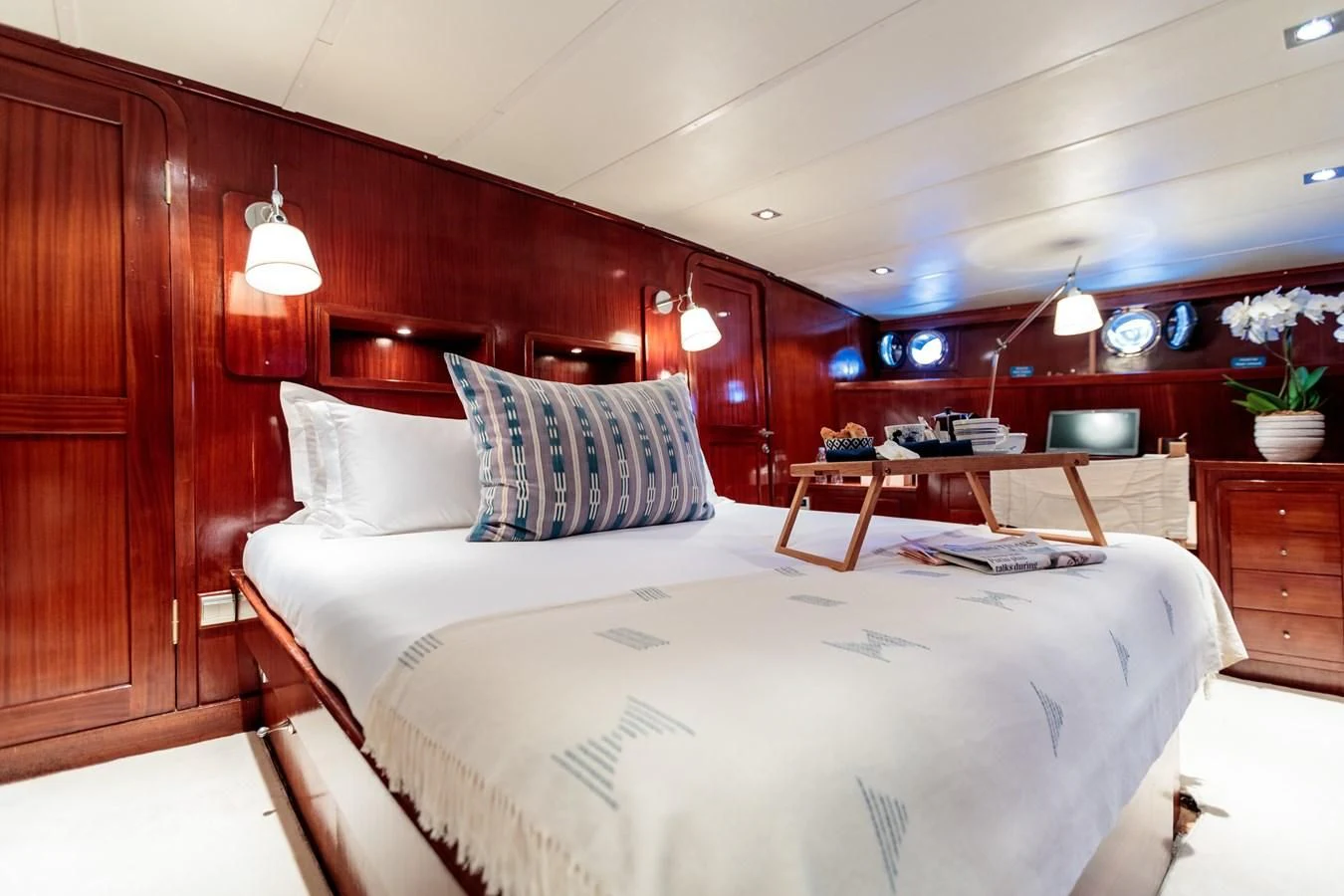 a bed with a white sheet and pillows in a room with wood walls aboard VITA DOLCE Yacht for Sale