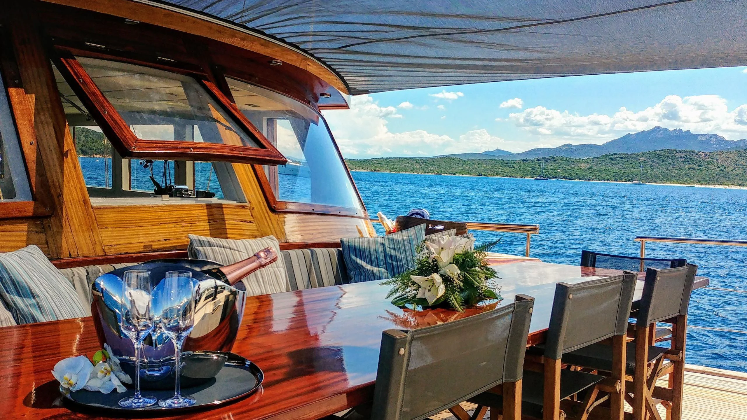 a table with chairs and a view of the ocean aboard VITA DOLCE Yacht for Sale