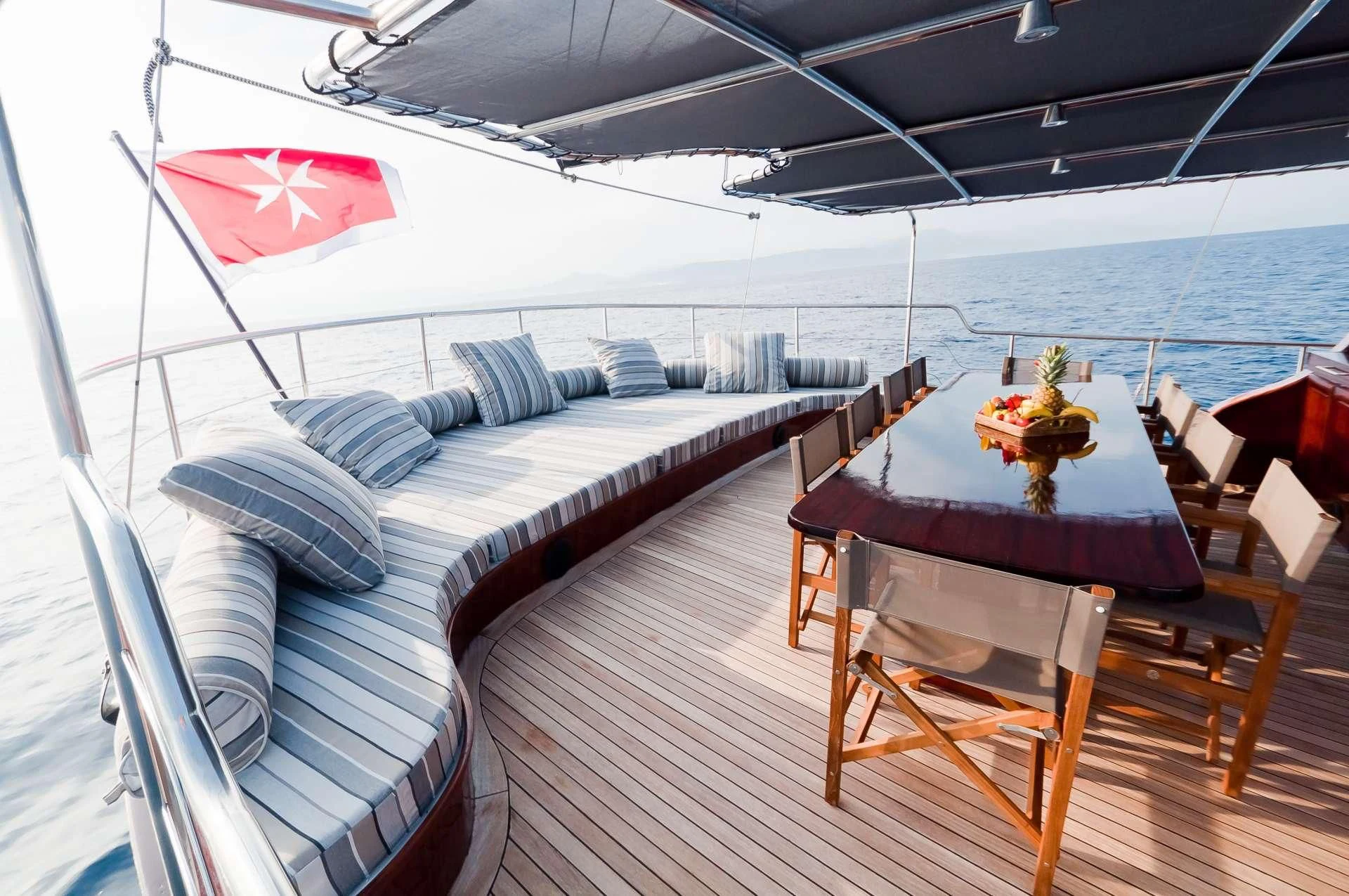 a deck with a table and chairs on it aboard VITA DOLCE Yacht for Sale