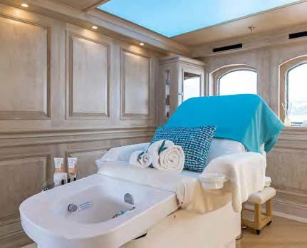 a bed with a blue sheet on it aboard NERO Yacht for Sale