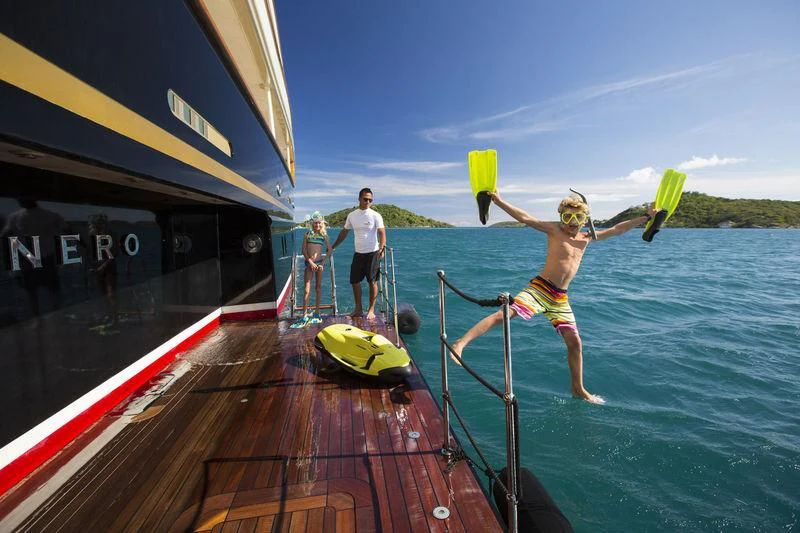 a boy jumping into a pool aboard NERO Yacht for Sale