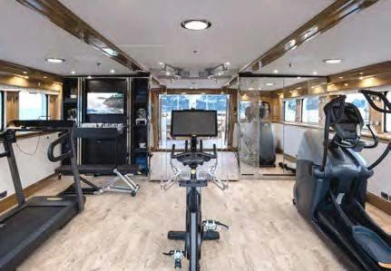 inside of a vehicle with a large screen and a table and chairs aboard NERO Yacht for Sale