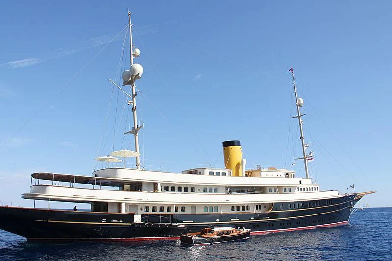 a large ship in the water with Huáscar in the background aboard NERO Yacht for Sale
