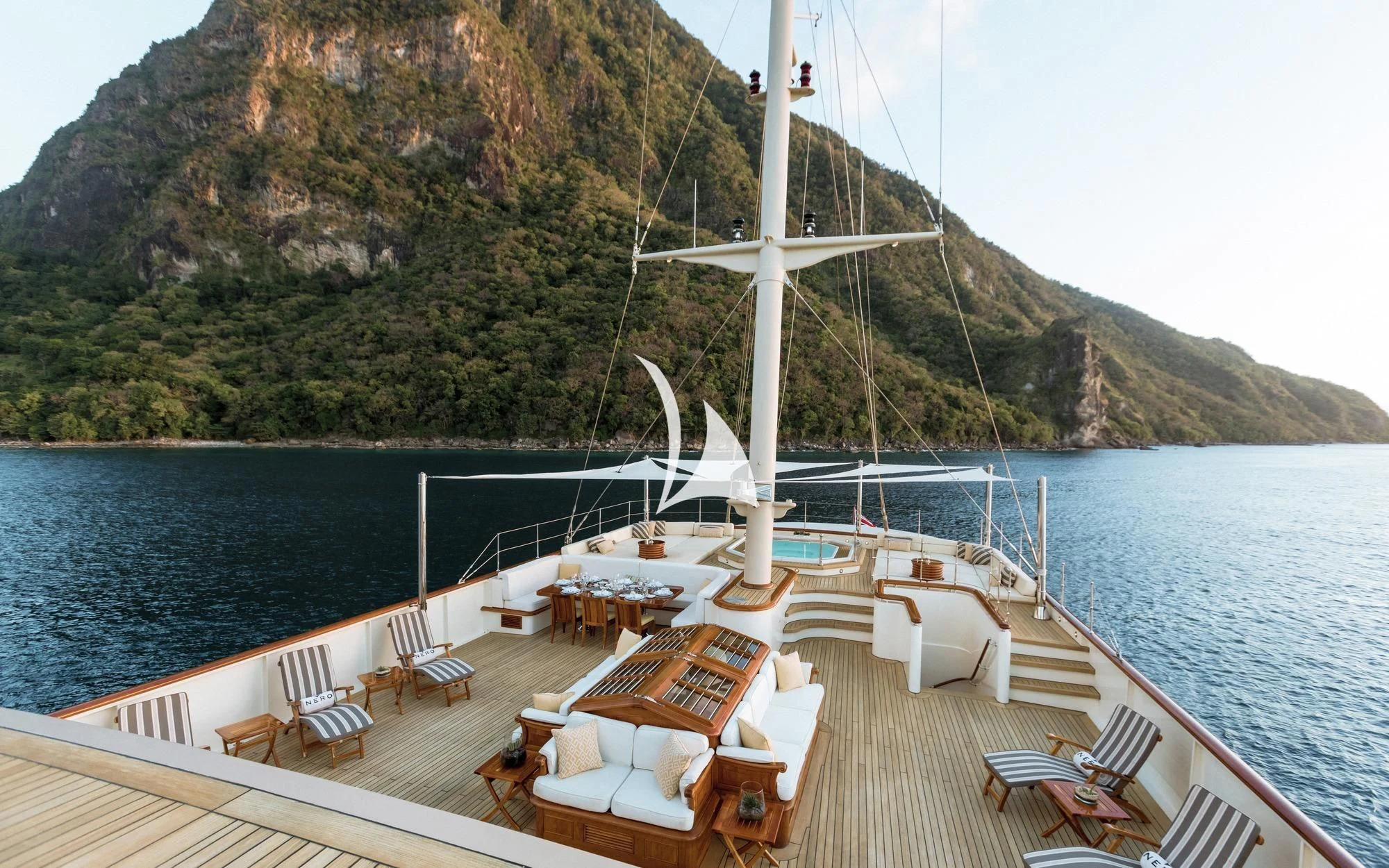 a deck with a boat on it and a table and chairs on it aboard NERO Yacht for Sale