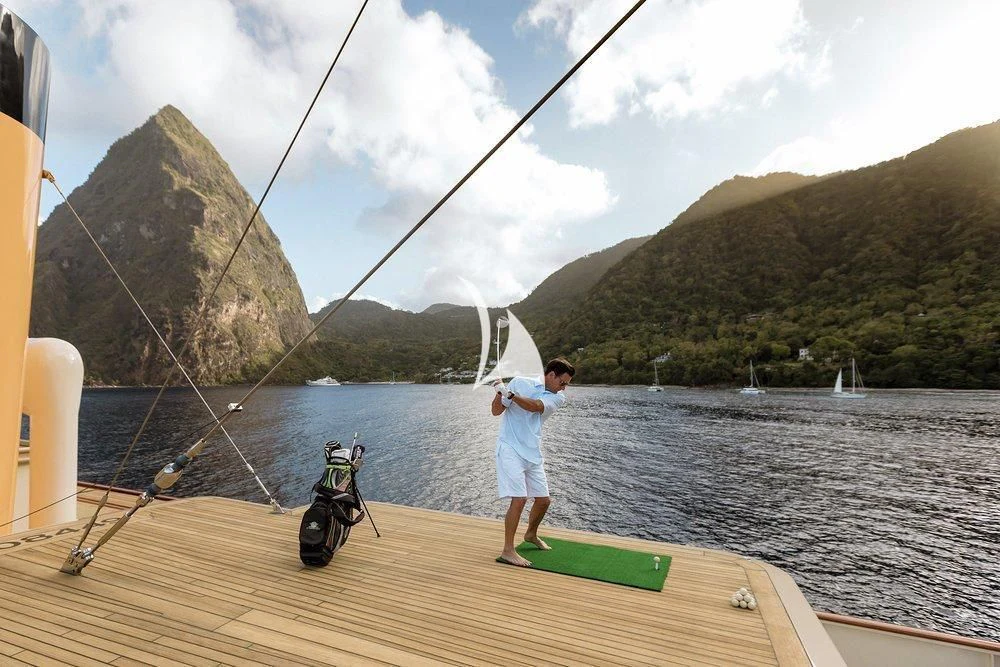 a person standing on a dock with a fishing pole and a boat in the water aboard NERO Yacht for Sale