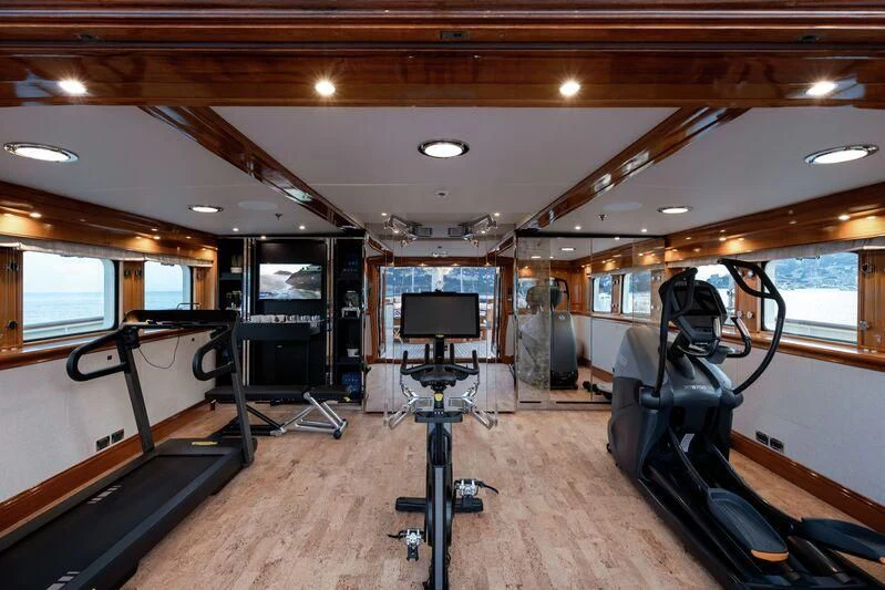 inside of a vehicle with a large screen and a table and chairs aboard NERO Yacht for Sale