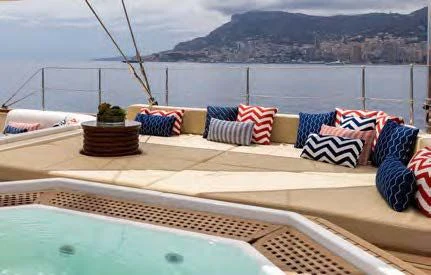 a deck with a view of the ocean and mountains aboard NERO Yacht for Sale