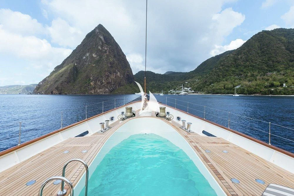 a swimming pool next to a large rock mountain aboard NERO Yacht for Sale