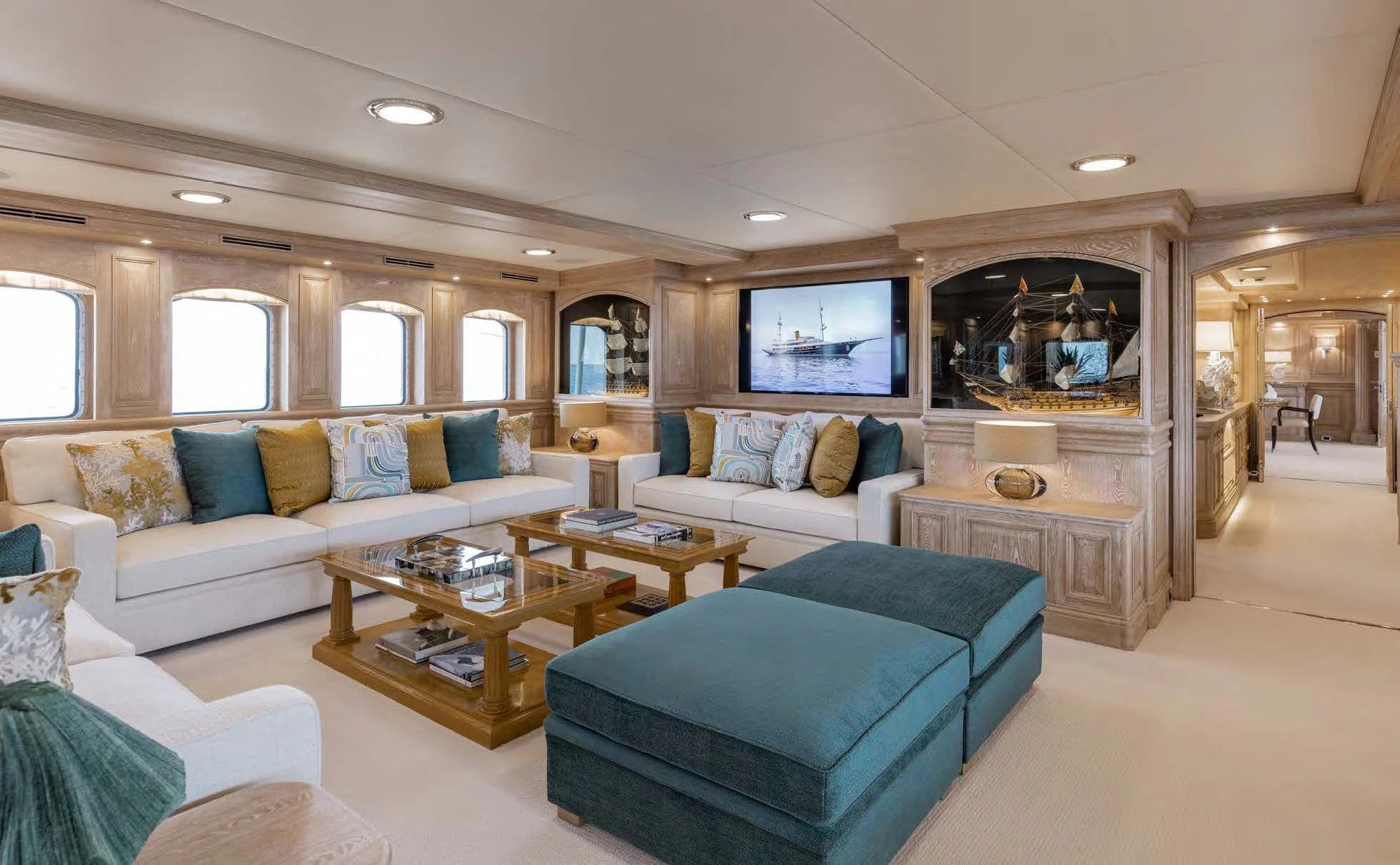 a living room with a blue couch and a coffee table aboard NERO Yacht for Sale