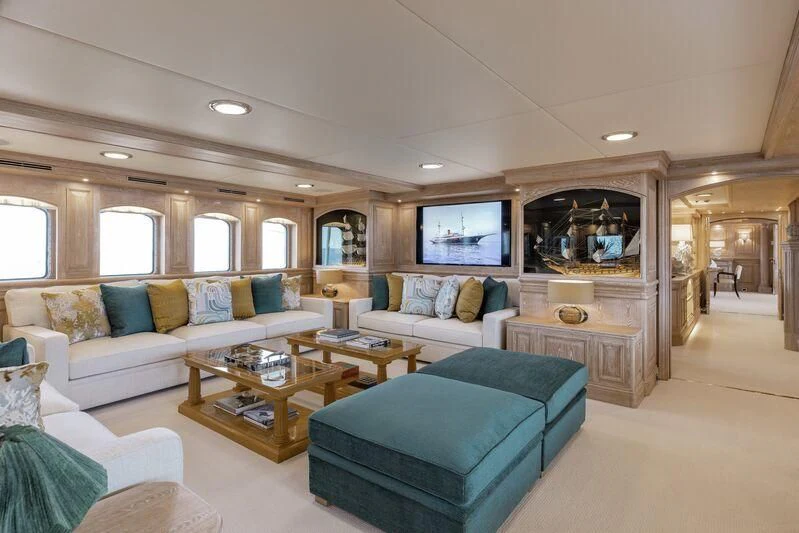 a living room with a blue couch and a coffee table aboard NERO Yacht for Sale
