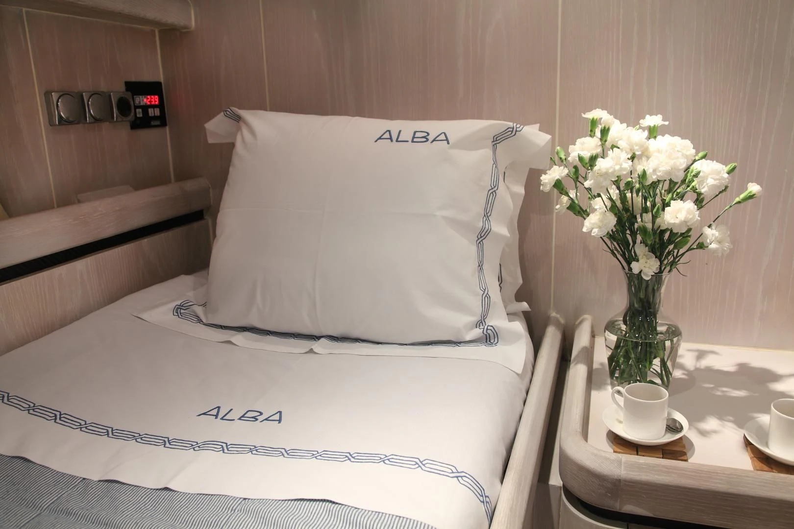 a bed with white pillows and white flowers in a room aboard MARIA ALBA II Yacht for Sale