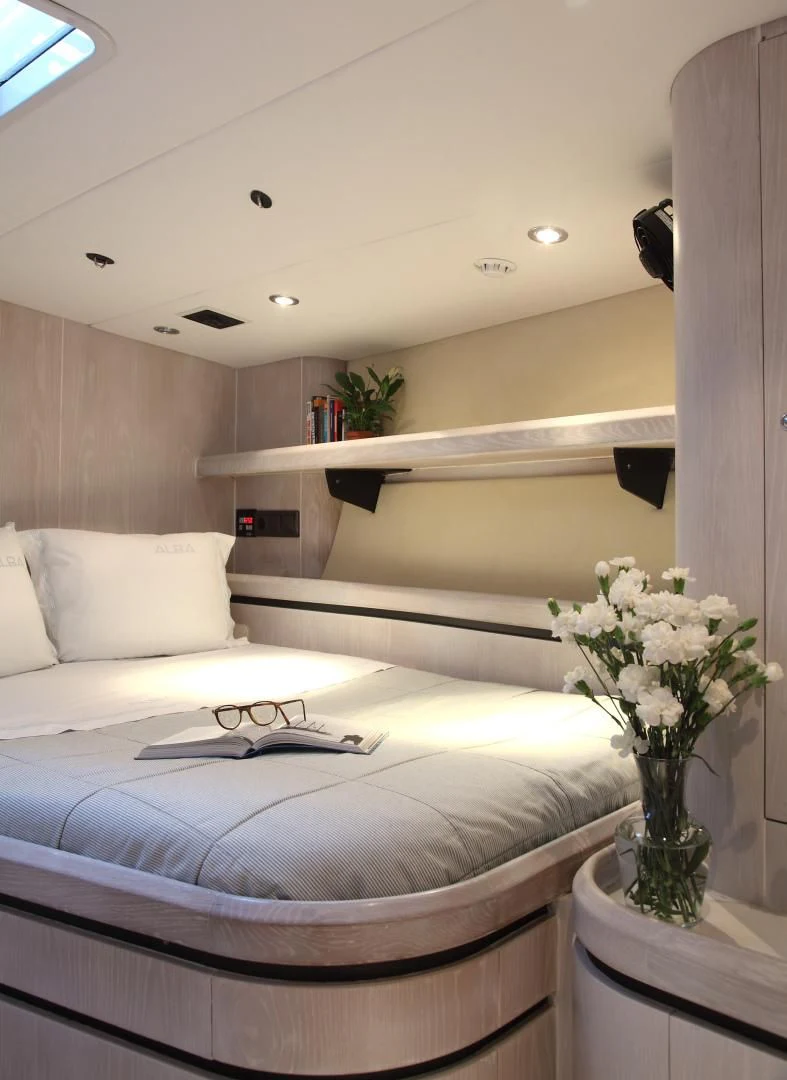 a room with a bed and a shelf with flowers aboard MARIA ALBA II Yacht for Sale
