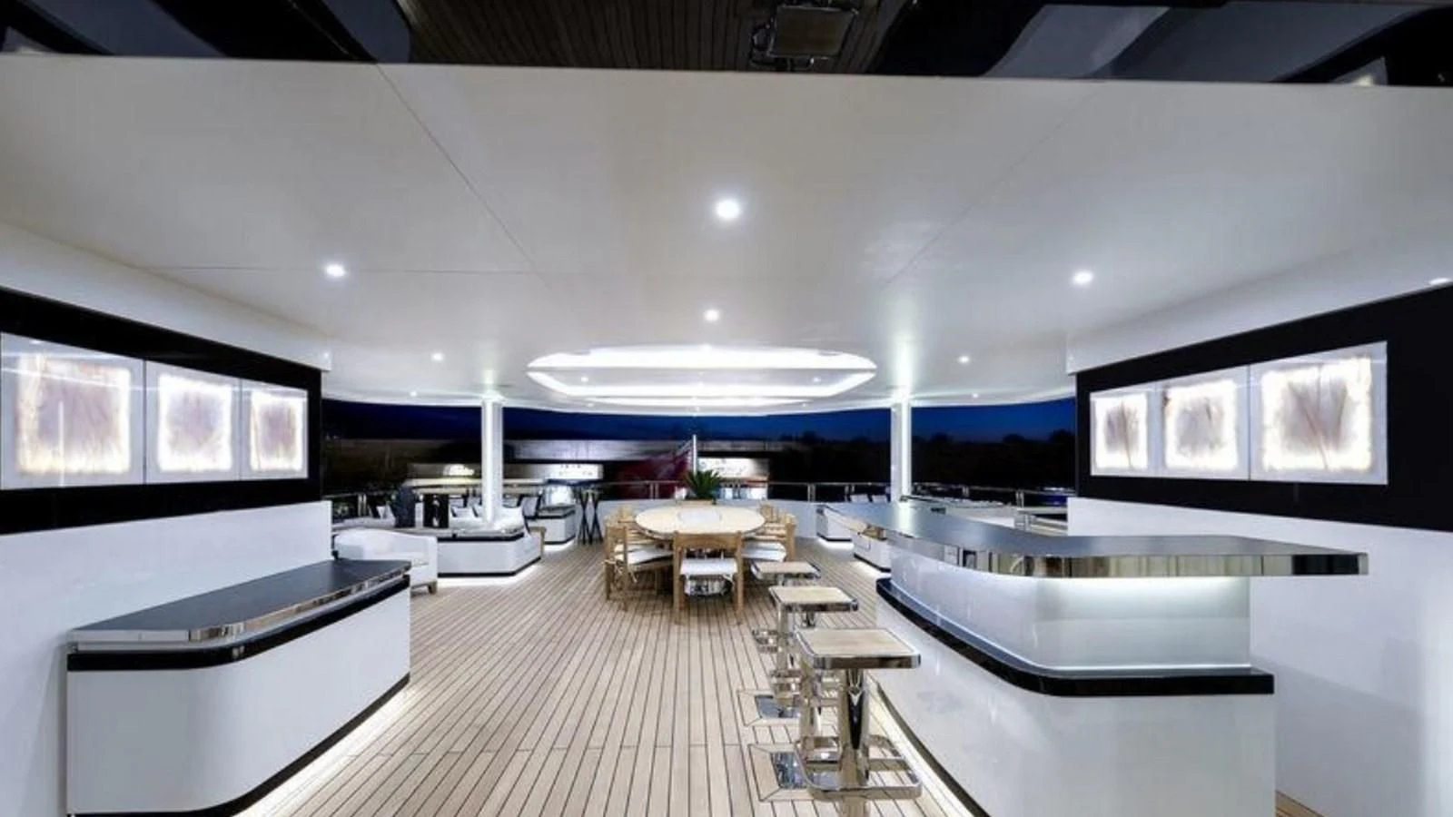 a room with a large screen and a table with chairs and a large window with a view of aboard M 47 Yacht for Sale