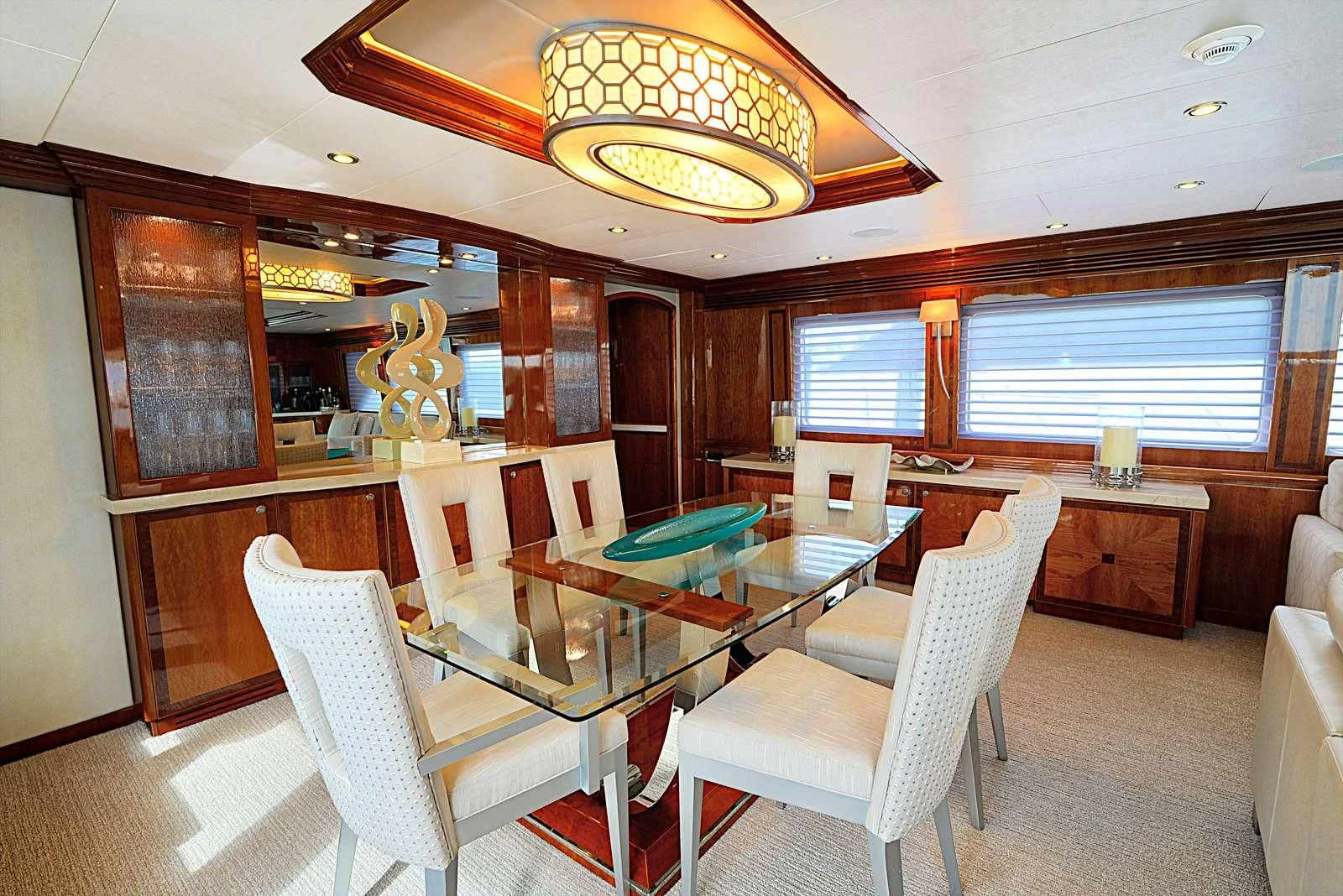 a room with a table chairs and a chandelier aboard STERLING V Yacht for Sale