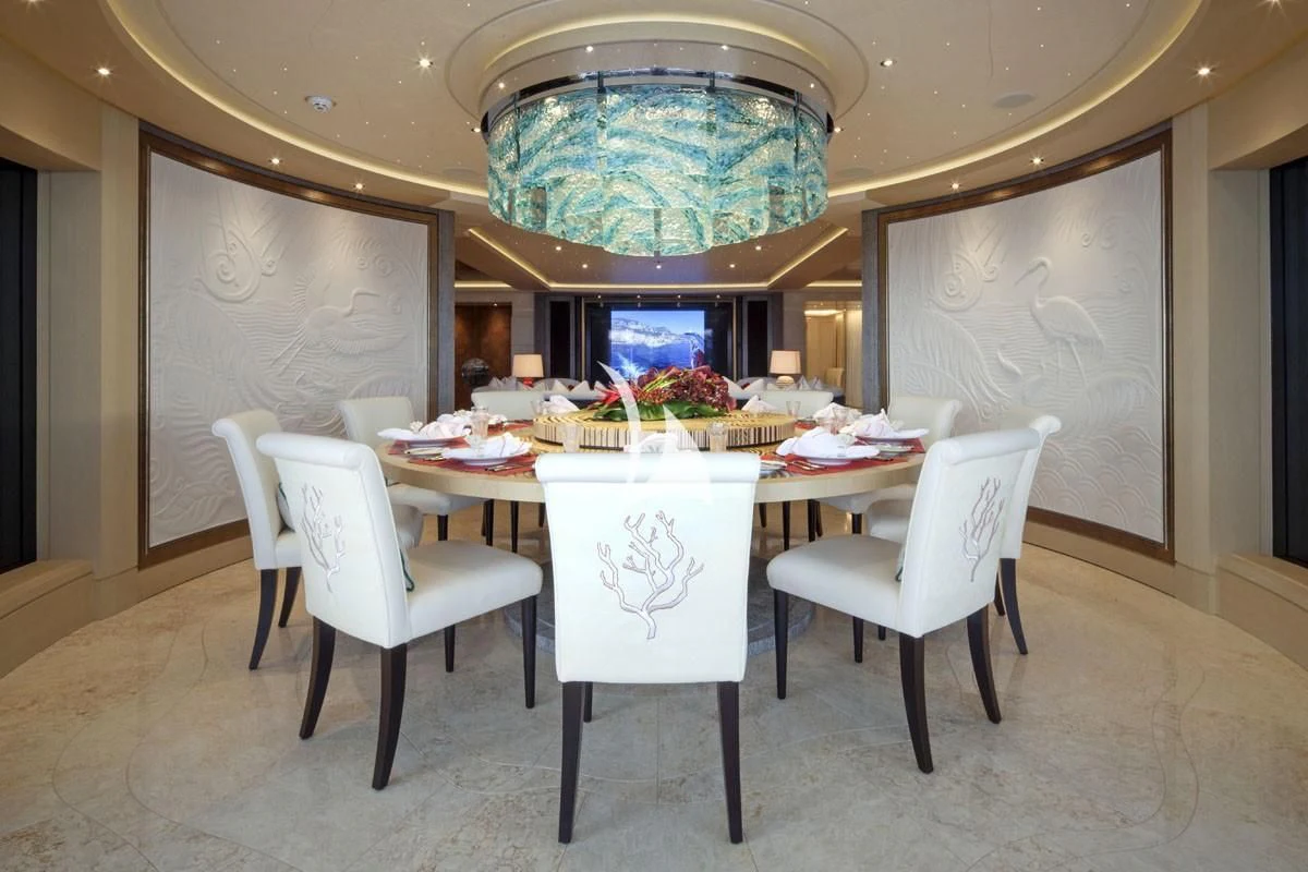 a dining room with a chandelier aboard DRAAK Yacht for Sale