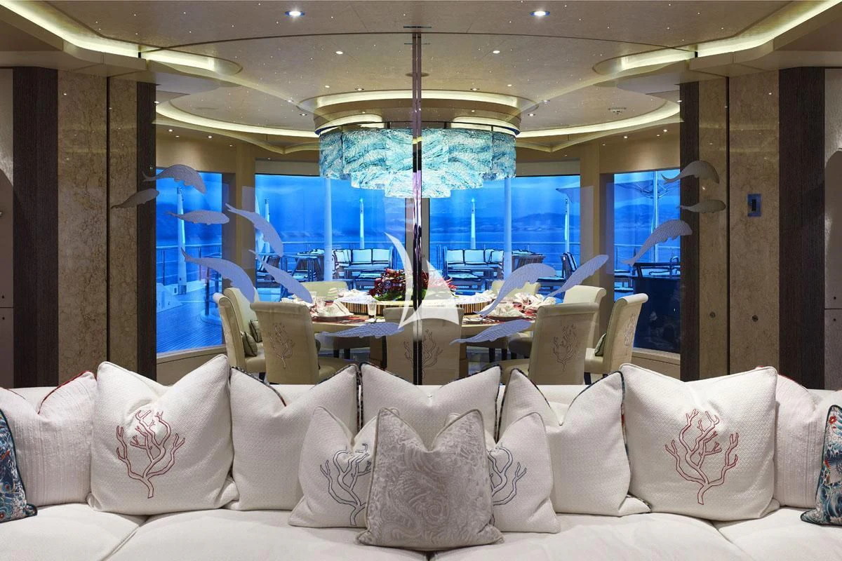 a room with a couch and a table with chairs and a large window aboard DRAAK Yacht for Sale