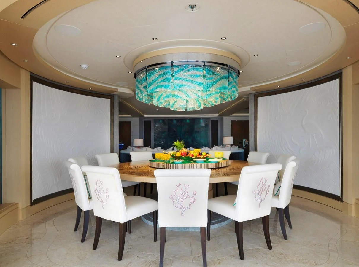 a table with chairs and a large globe on top aboard DRAAK Yacht for Sale