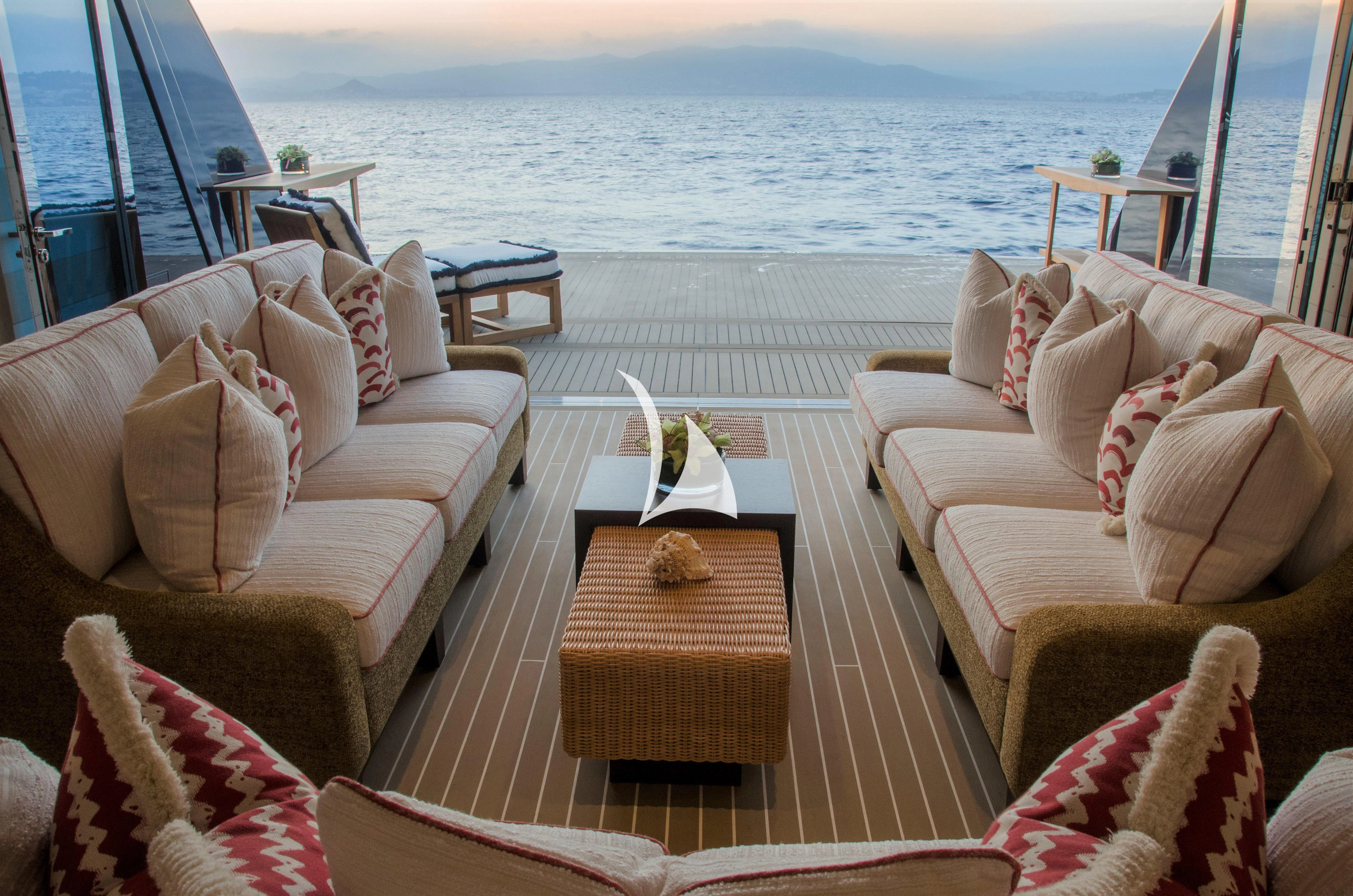 a deck with chairs and a table on it aboard DRAAK Yacht for Sale
