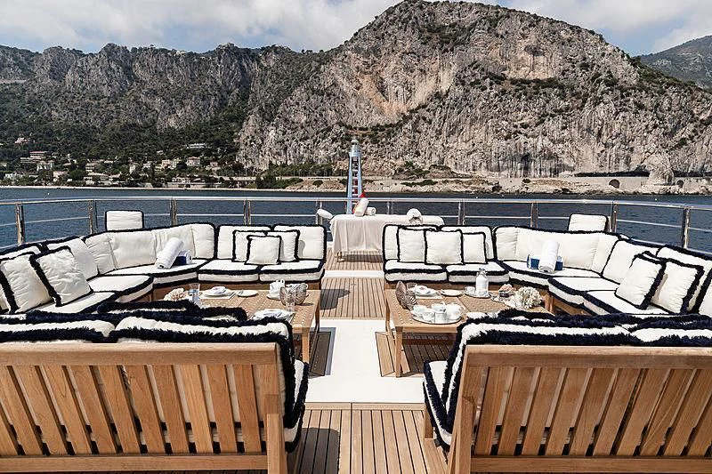 a room with a large group of chairs and a large mountain in the background aboard DRAAK Yacht for Sale