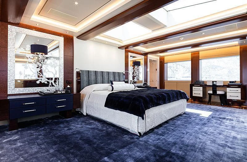 a bedroom with a bed and a desk aboard DRAAK Yacht for Sale