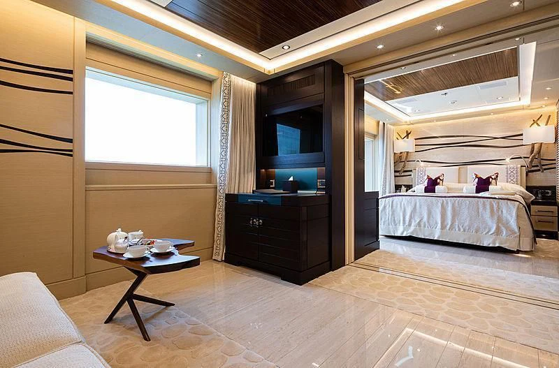 a bedroom with a bed and a table aboard DRAAK Yacht for Sale