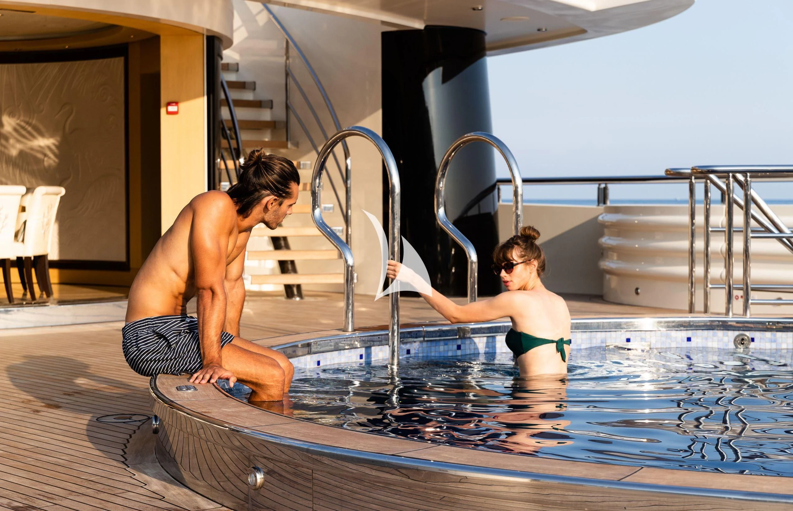 a couple of boys playing in a pool aboard DRAAK Yacht for Sale