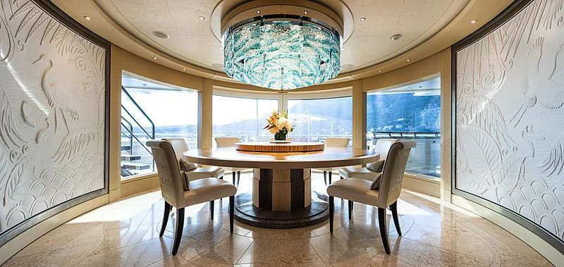 a room with a table and chairs aboard DRAAK Yacht for Sale