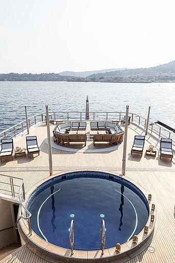 a deck with chairs on it by a body of water aboard DRAAK Yacht for Sale