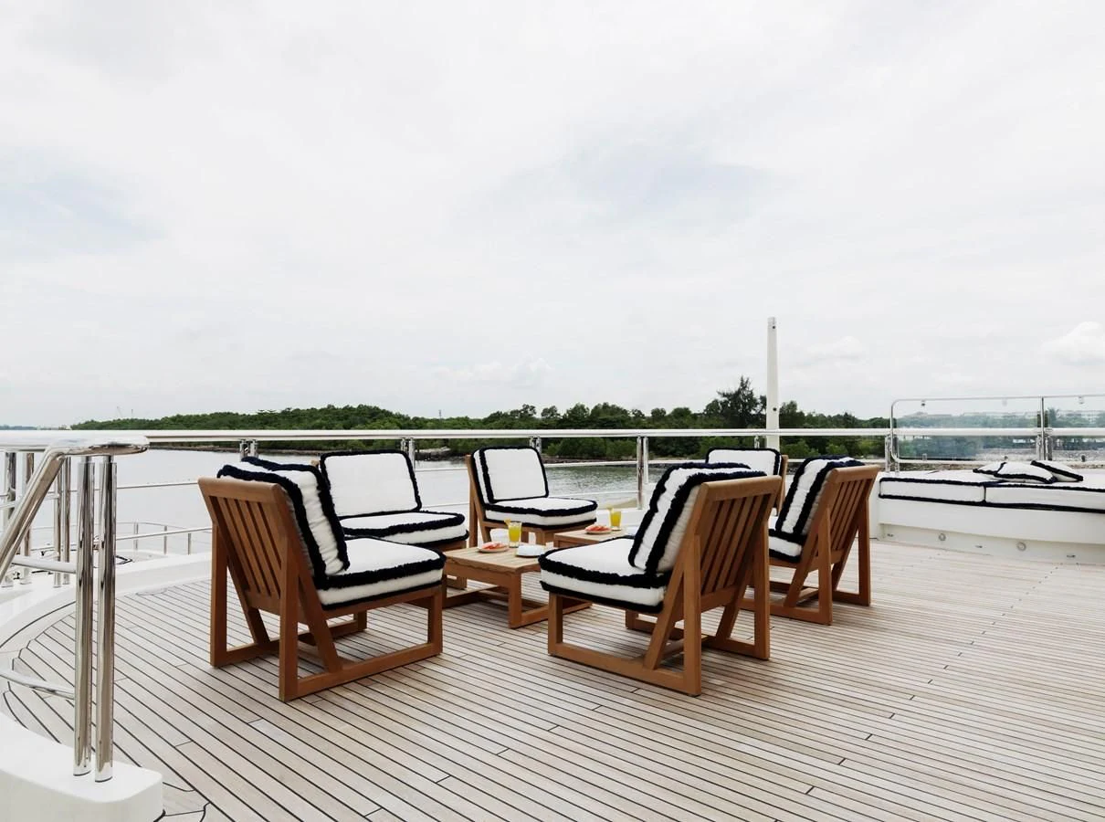 a deck with chairs and a table on it aboard DRAAK Yacht for Sale