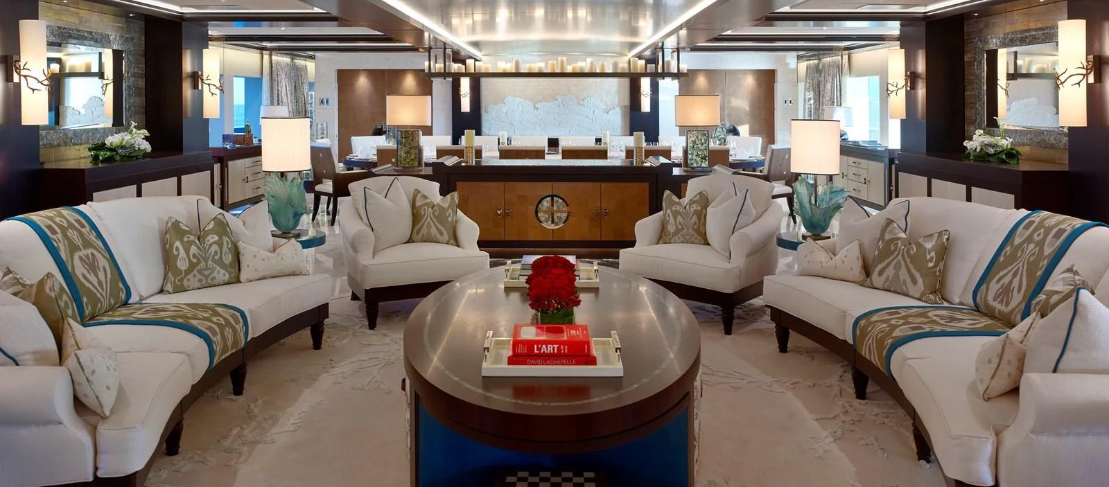 a living room with a large table and couches aboard DRAAK Yacht for Sale