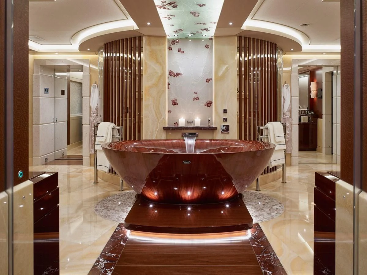 a large round red table in a room with chairs and a large chandelier aboard DRAAK Yacht for Sale