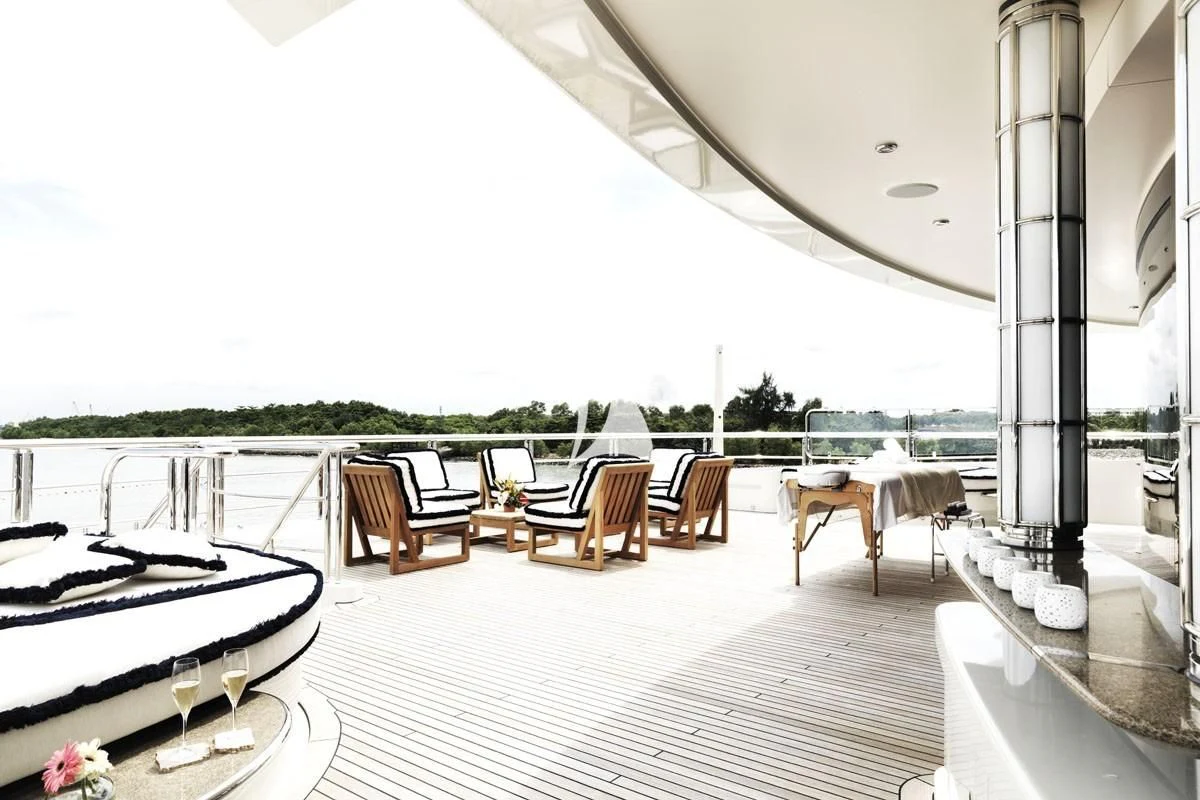 a large white building with a patio and tables and chairs aboard DRAAK Yacht for Sale