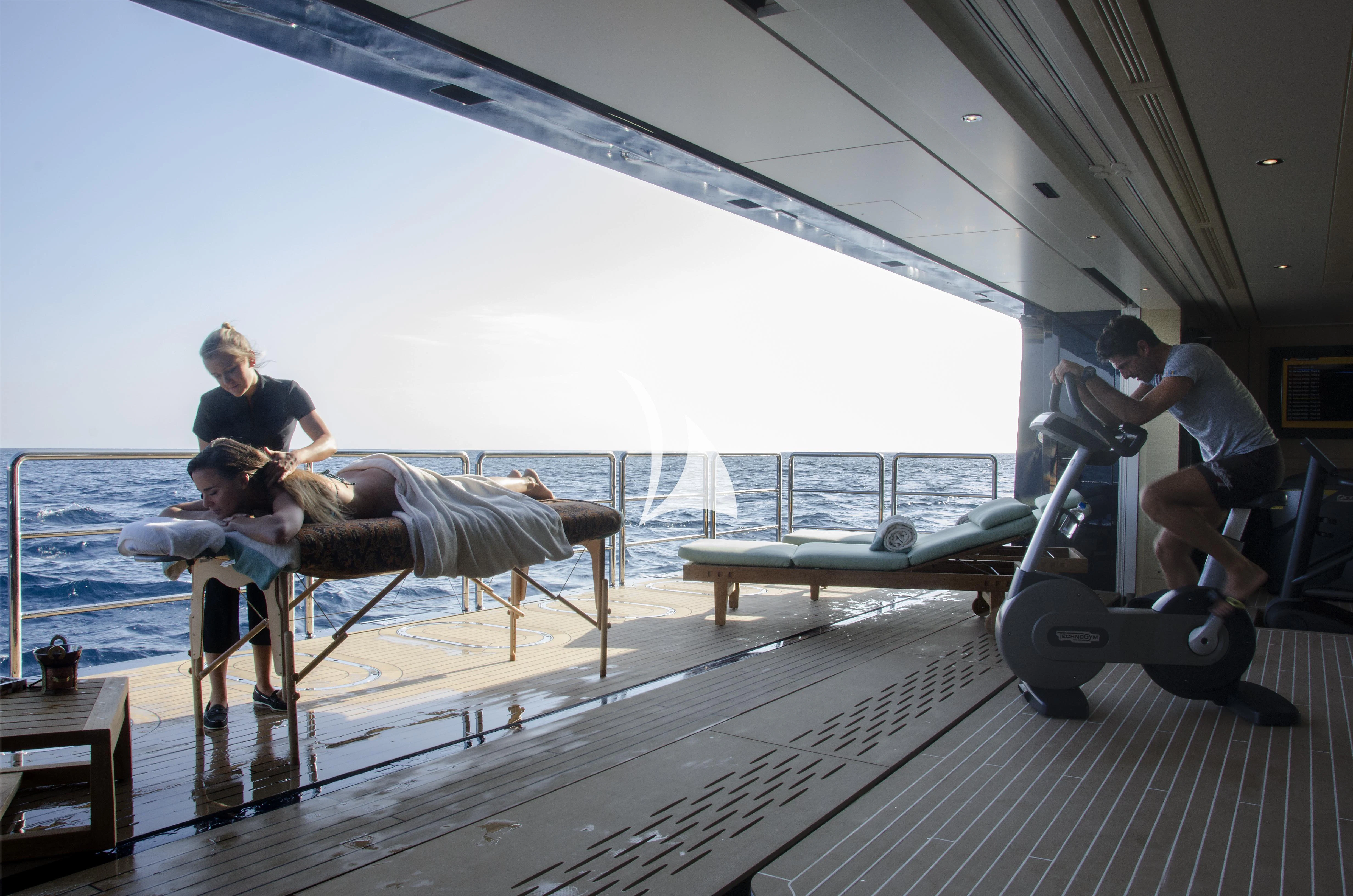 a man and a woman on a bench by a body of water aboard DRAAK Yacht for Sale