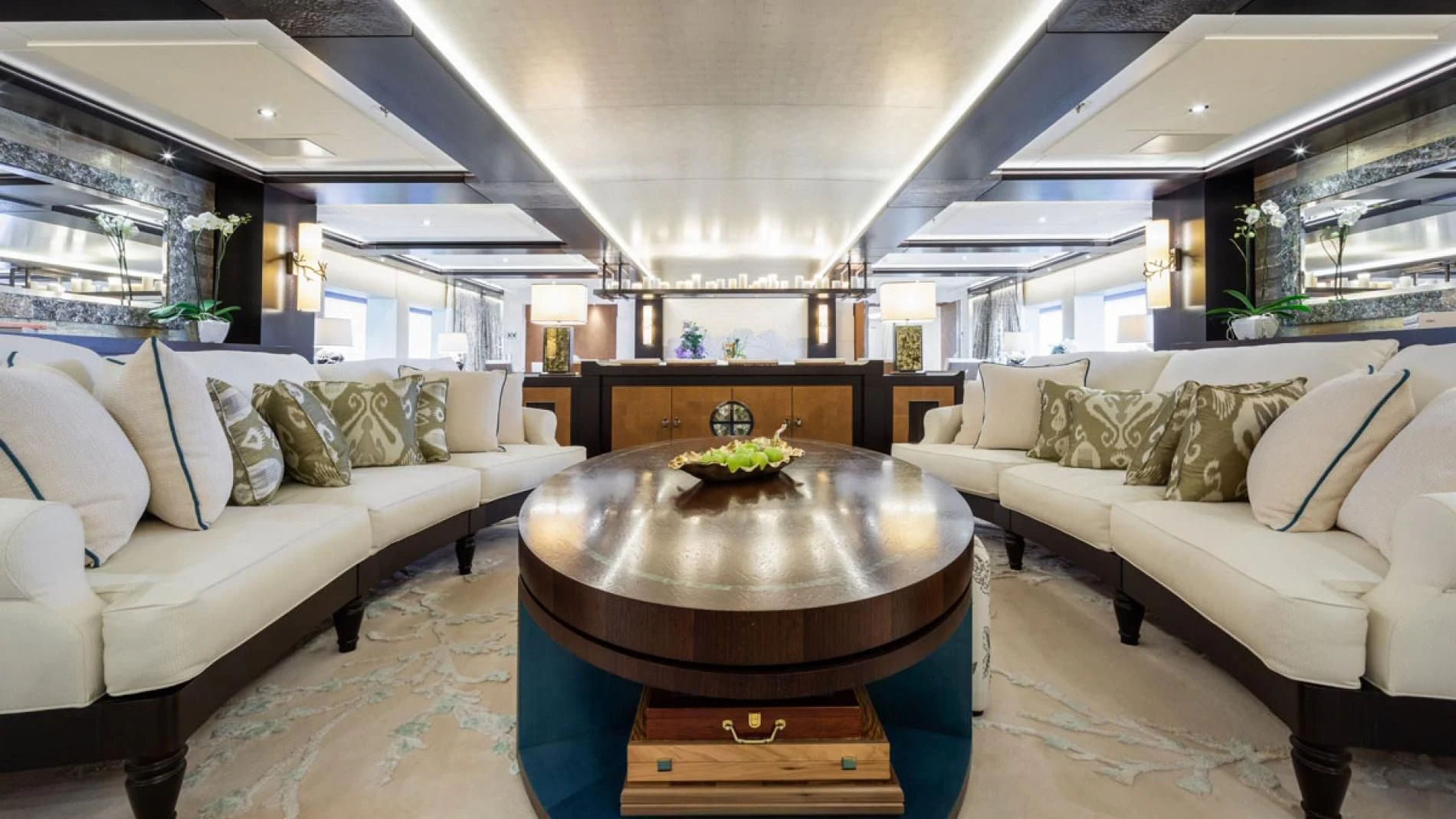 a living room with a large round table and couches aboard DRAAK Yacht for Sale