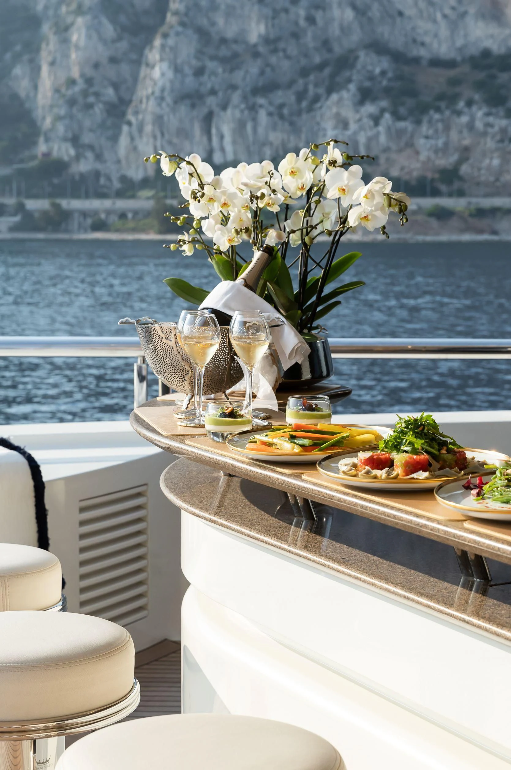 a table with food and glasses on it aboard DRAAK Yacht for Sale