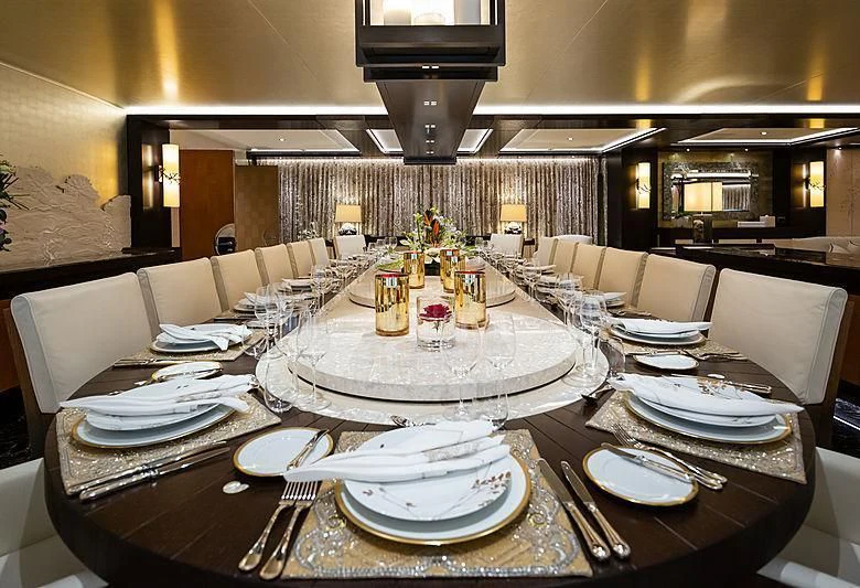 a table with plates and a cake on it aboard DRAAK Yacht for Sale