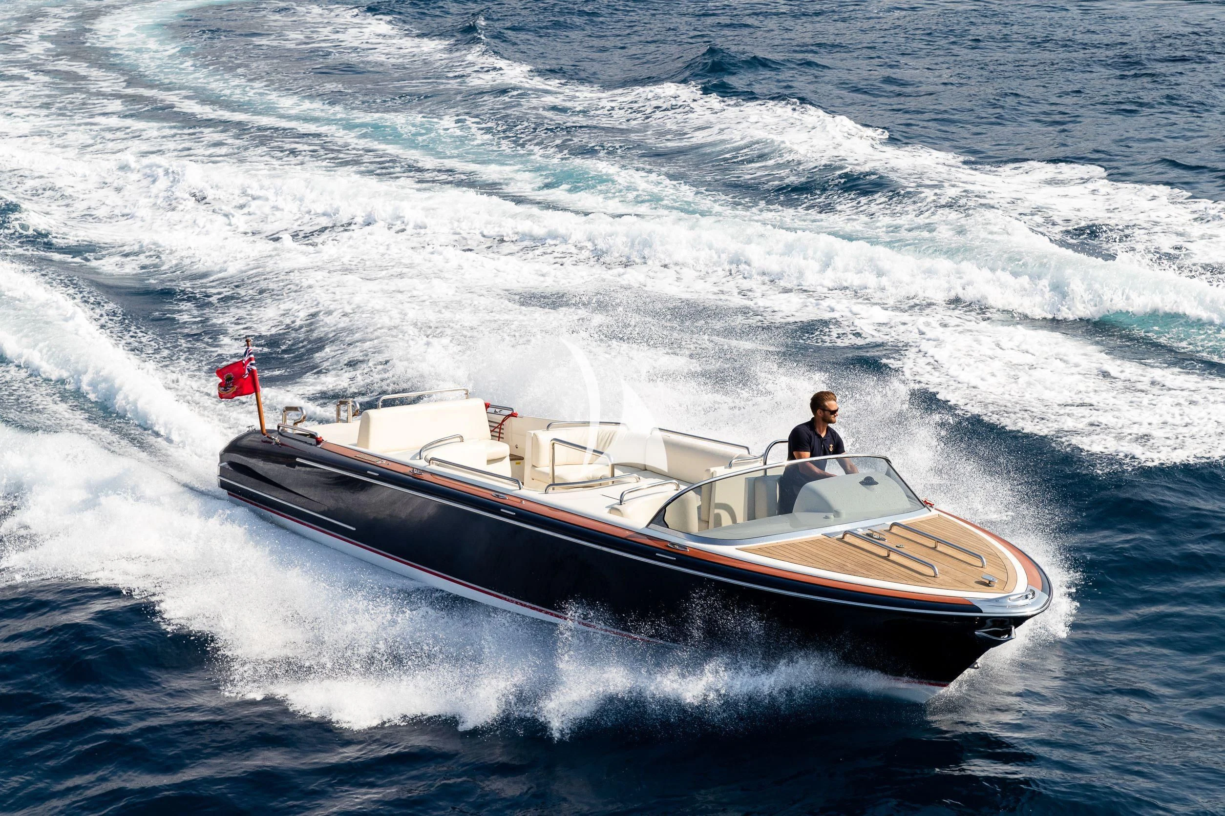 a man driving a boat on the water aboard DRAAK Yacht for Sale