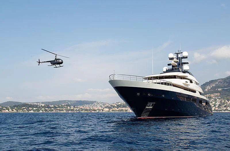 a helicopter flying over a ship in the water aboard DRAAK Yacht for Sale