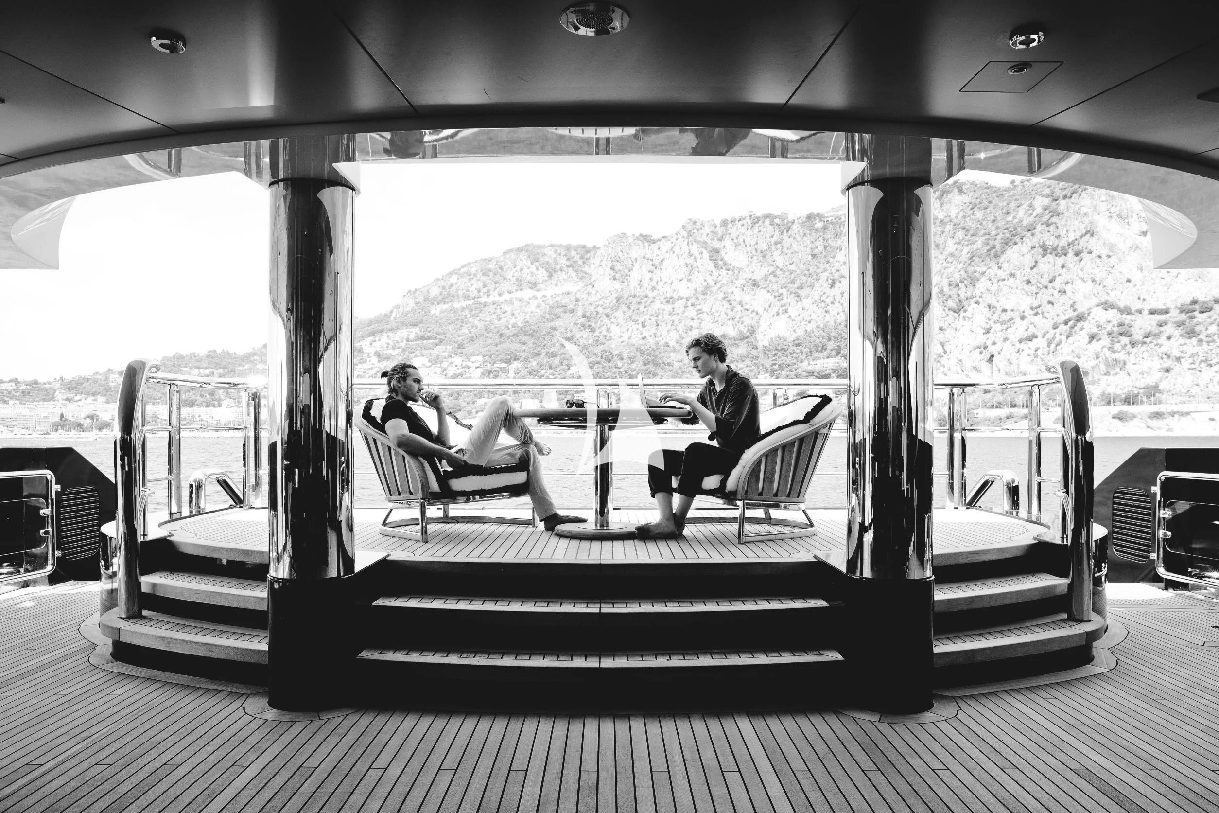 a couple of people sitting at a table on a deck aboard DRAAK Yacht for Sale