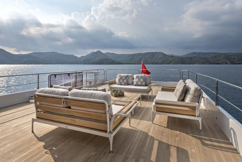a deck with a view of a body of water and mountains in the background aboard LADY STEFANI Yacht for Sale