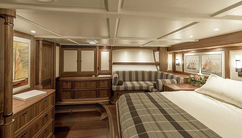 a room with a bed and a dresser aboard SVEA Yacht for Sale