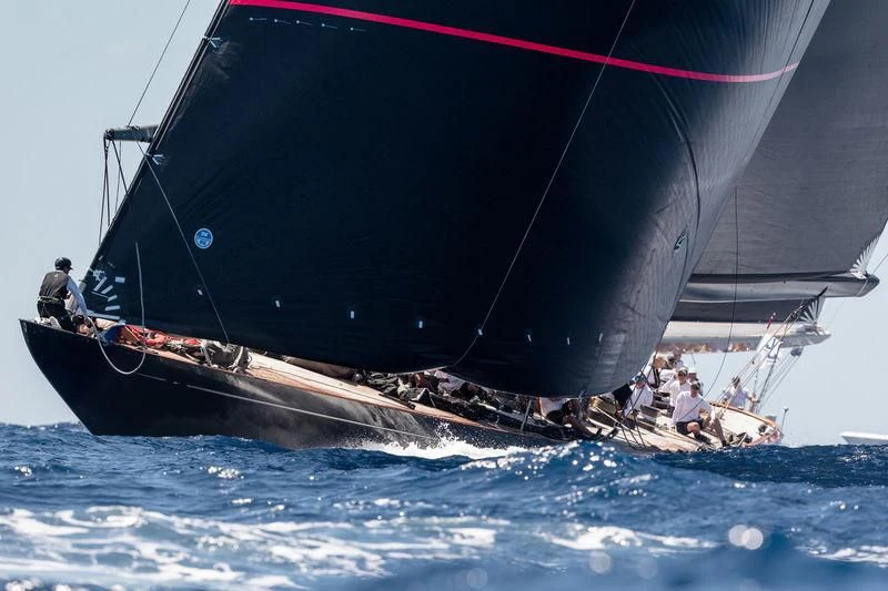 a large boat with a red and black sail aboard SVEA Yacht for Sale