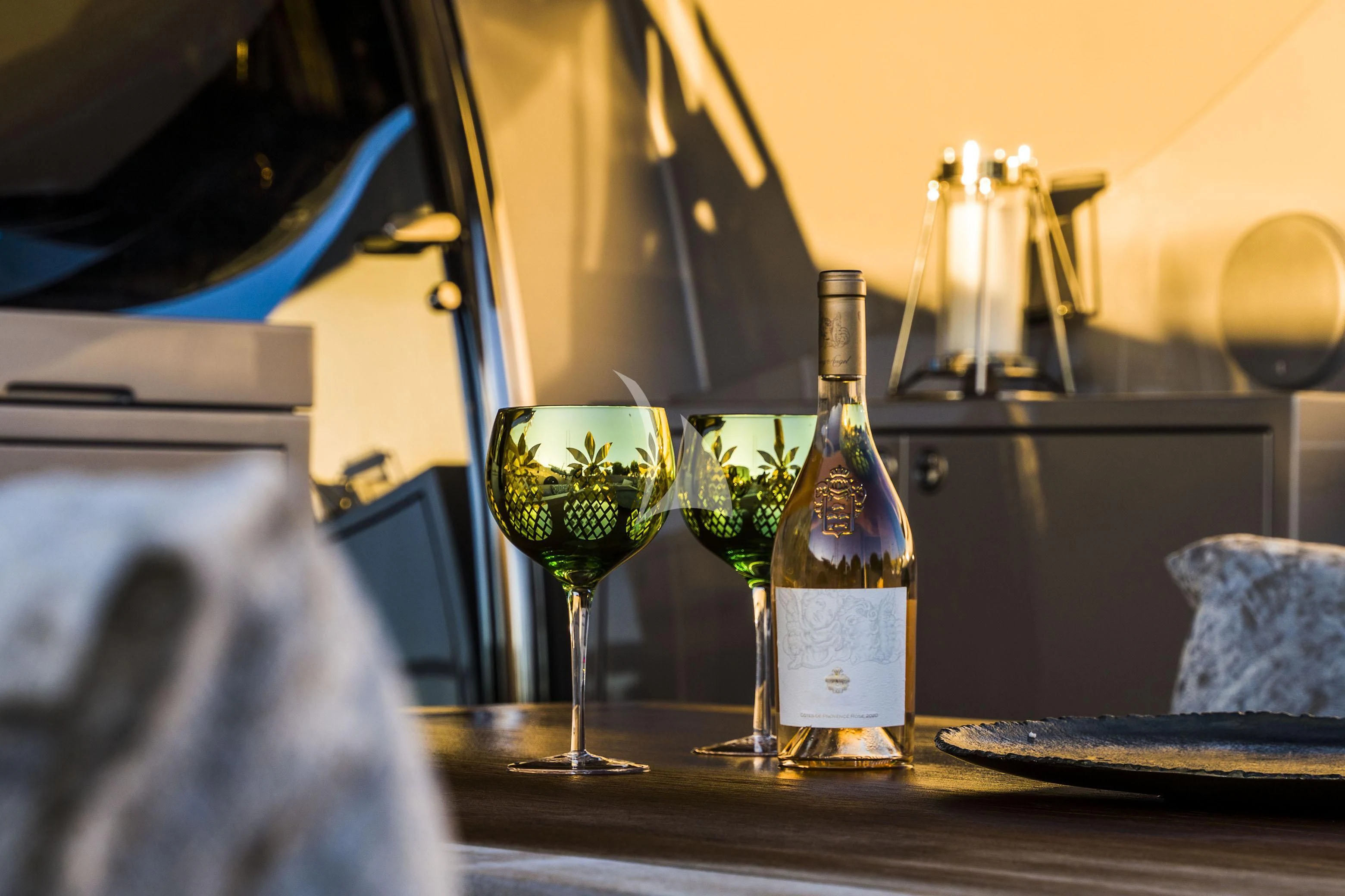 a bottle of champagne and a glass of champagne on a table aboard BAGHEERA Yacht for Charter