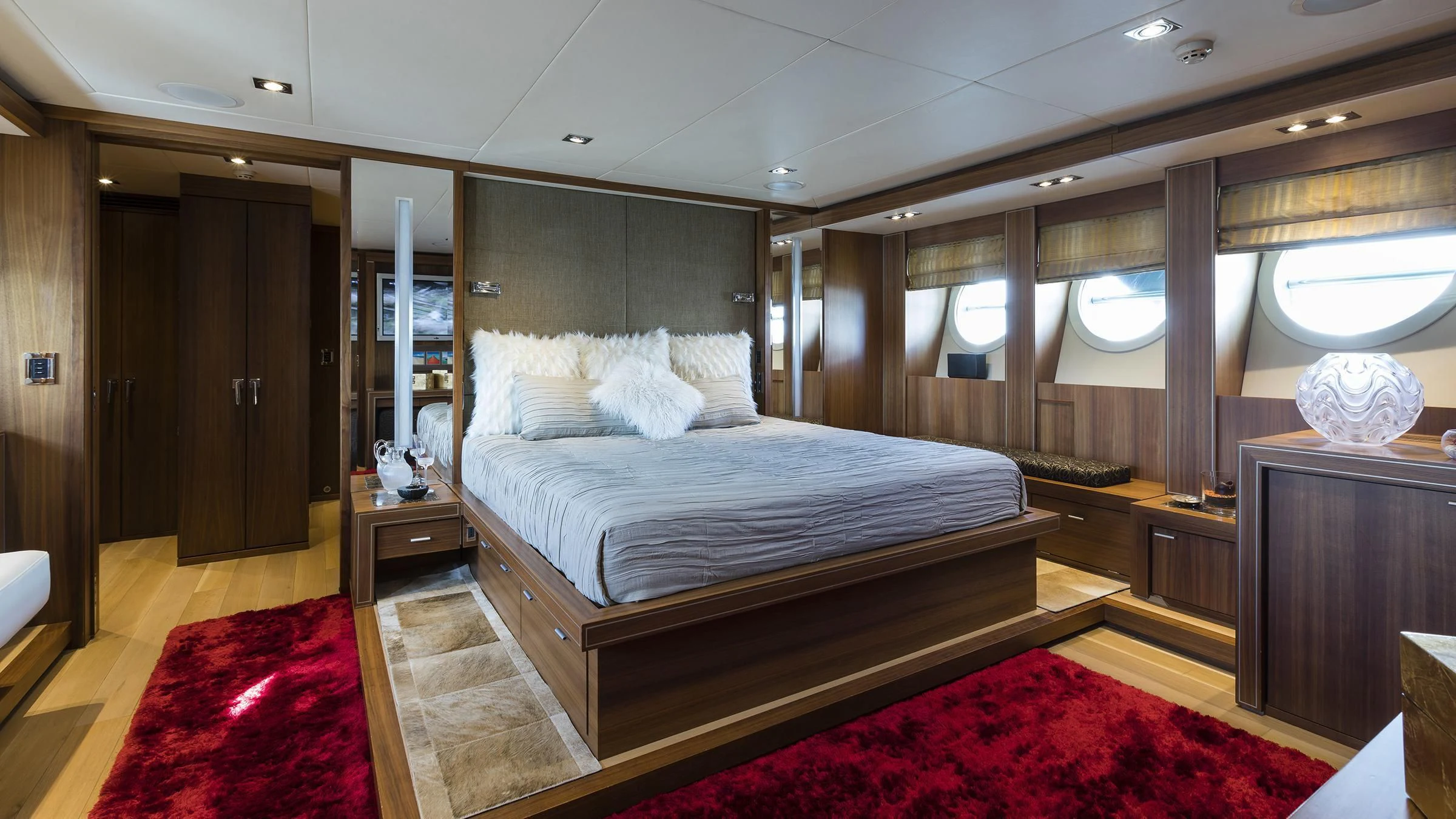 a bedroom with a bed and a mirror aboard BAGHEERA Yacht for Charter