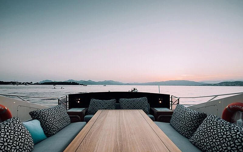 a deck with a view of the ocean and a large boat in the distance aboard BAGHEERA Yacht for Charter